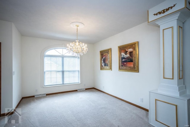 carpeted spare room with a notable chandelier