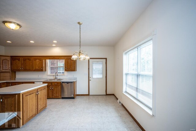 kitchen with plenty of natural light, hanging light fixtures, stainless steel dishwasher, and a center island