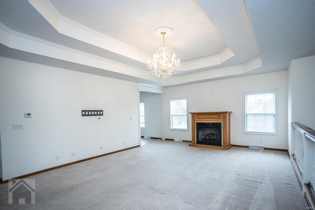 unfurnished living room with light colored carpet, a raised ceiling, a chandelier, and crown molding