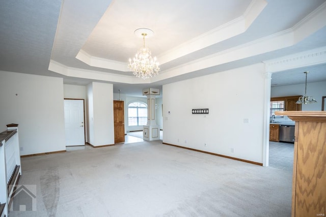 interior space with light carpet, sink, a notable chandelier, a tray ceiling, and ornamental molding