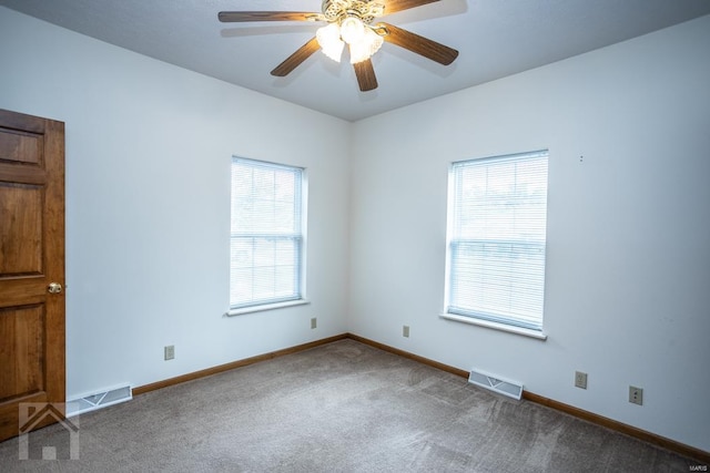 empty room featuring ceiling fan and carpet