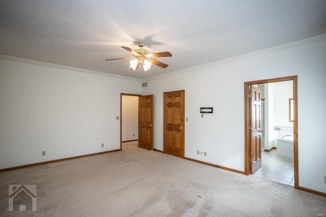 interior space featuring ceiling fan, crown molding, light carpet, and ensuite bath