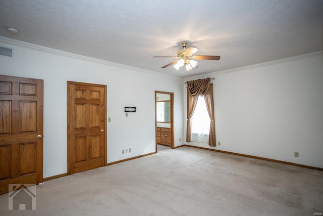 carpeted empty room with ceiling fan, a textured ceiling, and ornamental molding