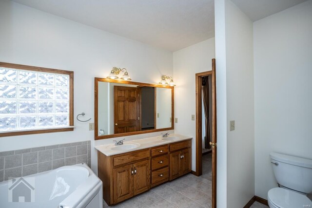 bathroom featuring vanity, toilet, tile patterned flooring, and a washtub