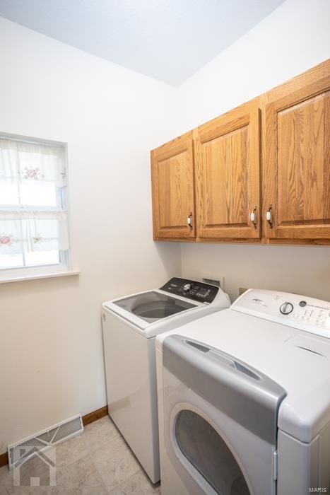 washroom with cabinets and washing machine and dryer