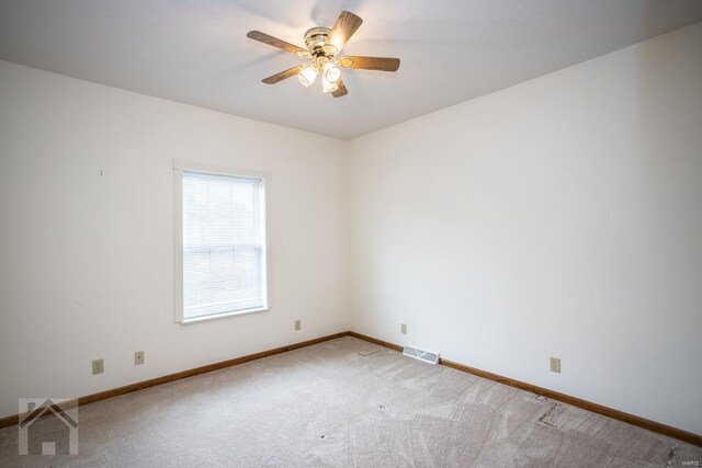 empty room with ceiling fan and light carpet