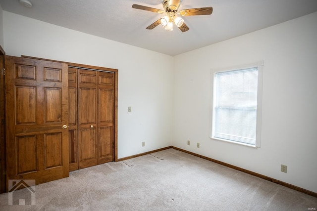 unfurnished bedroom featuring light colored carpet, ceiling fan, and a closet