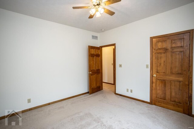 unfurnished bedroom featuring ceiling fan and light colored carpet