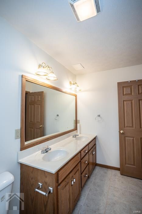 bathroom featuring vanity, toilet, and tile patterned floors