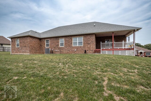 rear view of house featuring a yard and a deck