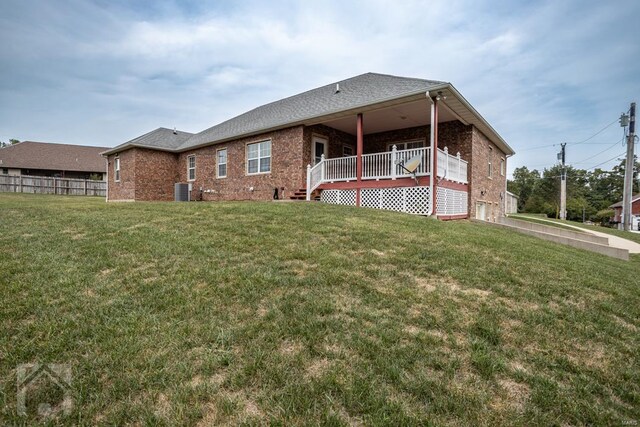 back of property featuring central air condition unit, a yard, and a garage