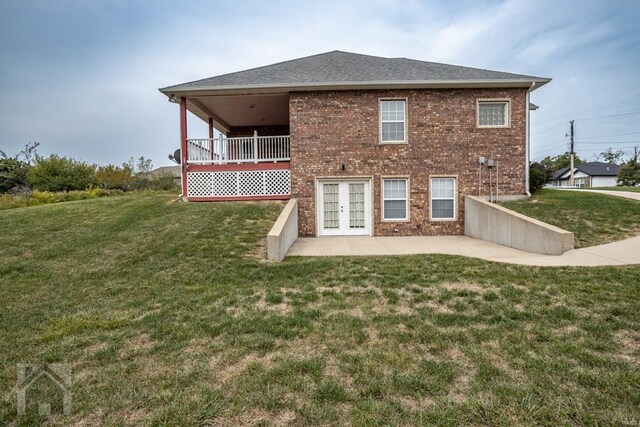 rear view of house with french doors, a patio area, and a yard