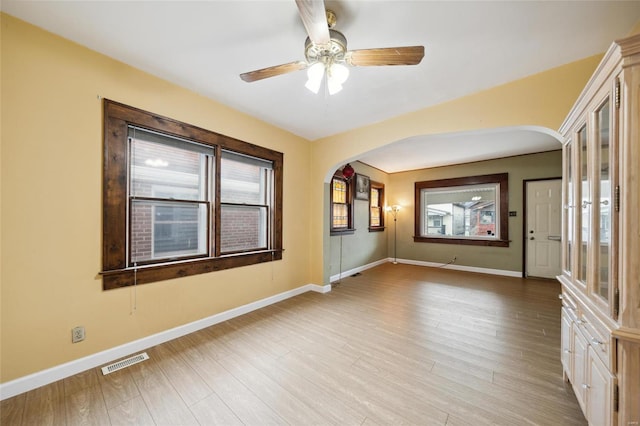 empty room with ceiling fan and light hardwood / wood-style floors