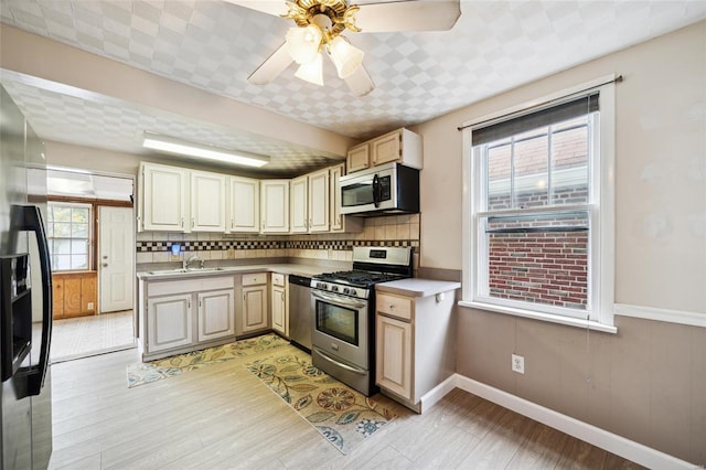 kitchen with tasteful backsplash, ceiling fan, stainless steel appliances, and light hardwood / wood-style floors