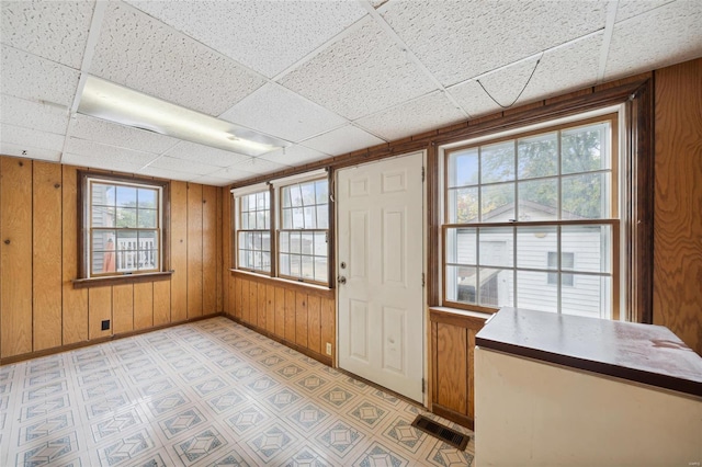 interior space with a wealth of natural light and a drop ceiling