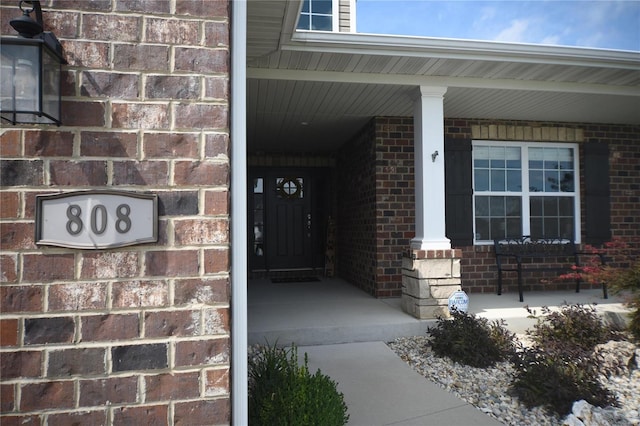 view of exterior entry featuring covered porch