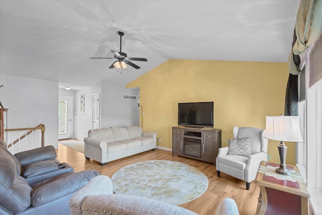 living room featuring ceiling fan, light hardwood / wood-style flooring, and vaulted ceiling