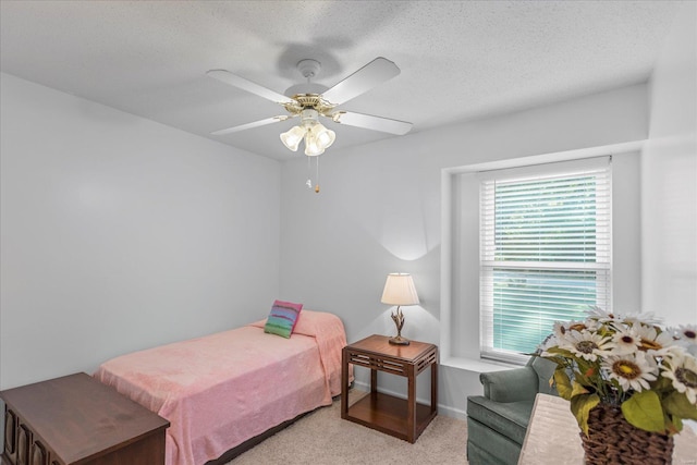 carpeted bedroom featuring a textured ceiling and ceiling fan