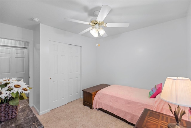 carpeted bedroom featuring a closet and ceiling fan