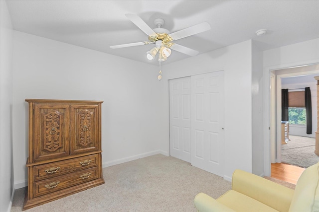 living area featuring ceiling fan and light carpet