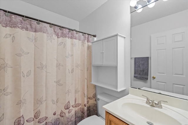 bathroom featuring a shower with shower curtain, vanity, toilet, and a textured ceiling