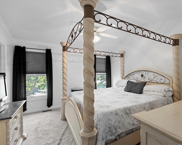 bedroom with ceiling fan, light colored carpet, and a textured ceiling