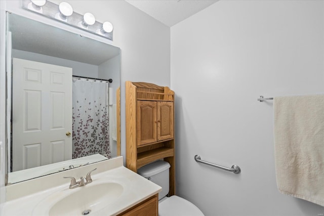 bathroom with a shower with shower curtain, vanity, toilet, and a textured ceiling