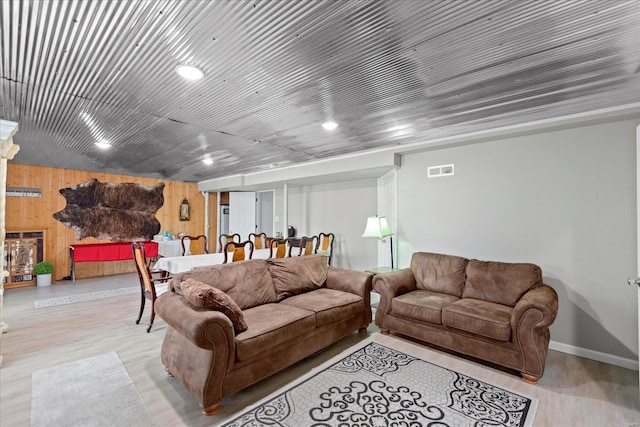 living room featuring light hardwood / wood-style floors and wooden walls