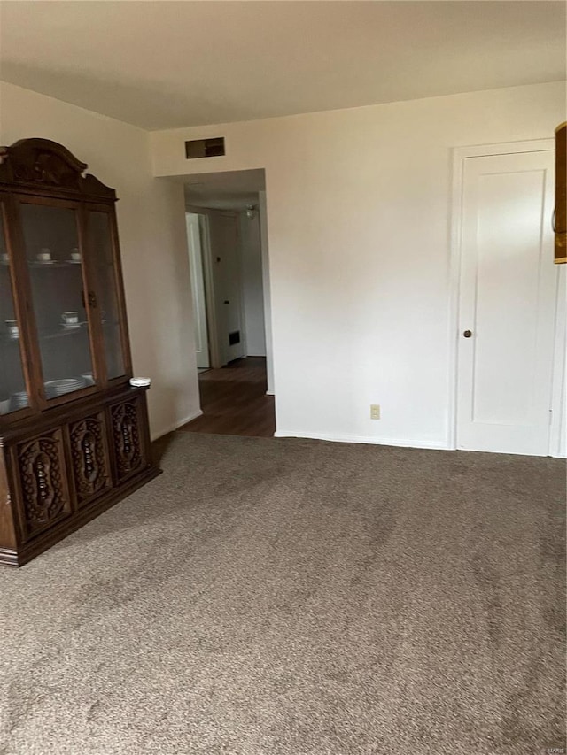 unfurnished room with dark carpet