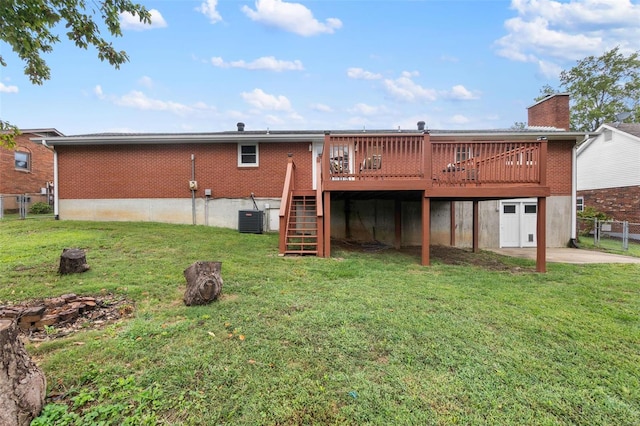 rear view of house with a lawn, a wooden deck, and central AC unit