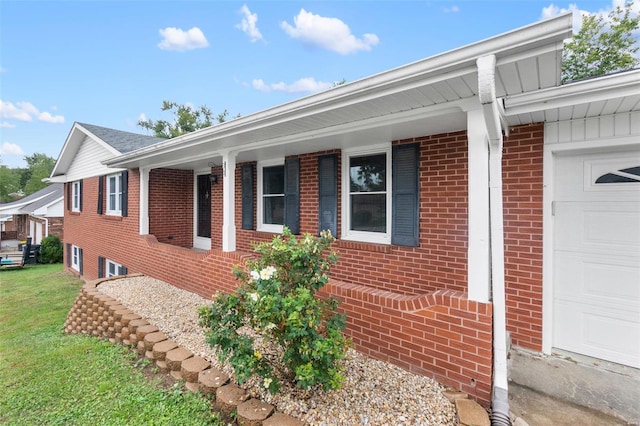 view of side of property with a garage, a yard, and brick siding