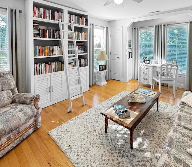 sitting room with a wealth of natural light, ceiling fan, and light wood-type flooring