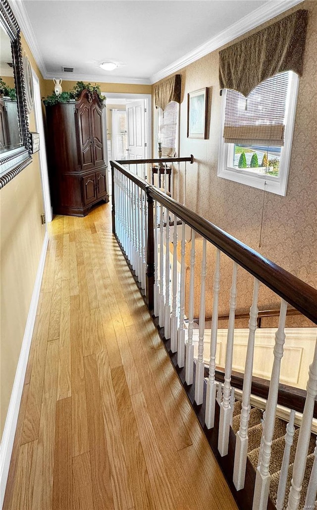 hall with crown molding and light hardwood / wood-style flooring