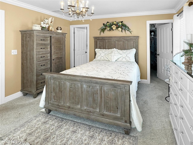 carpeted bedroom with ornamental molding, a chandelier, a walk in closet, and a closet