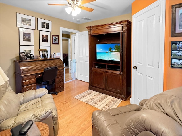 living room featuring light wood-type flooring and ceiling fan