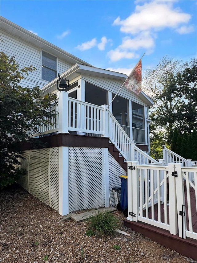 view of home's exterior featuring a wooden deck and a sunroom