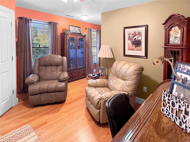 living room featuring light wood-type flooring and ceiling fan