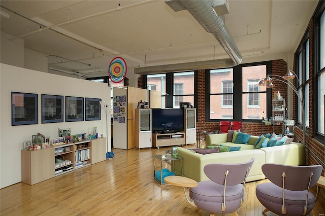 living room with brick wall and wood-type flooring