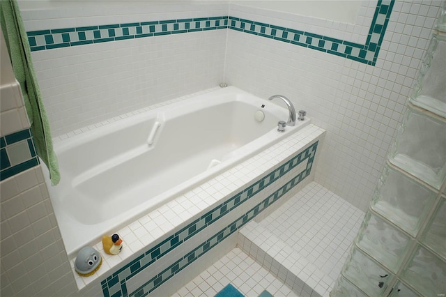 bathroom with tile patterned floors and tiled tub