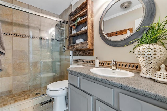 bathroom featuring vanity, tile patterned flooring, a shower with shower door, crown molding, and toilet