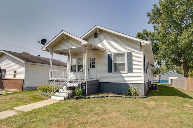 view of front facade with a porch, central AC unit, and a front lawn