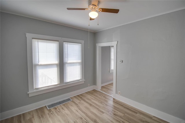 spare room featuring crown molding, ceiling fan, and light wood-type flooring