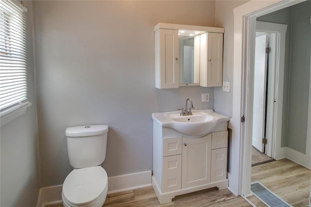 bathroom with hardwood / wood-style floors, toilet, and vanity