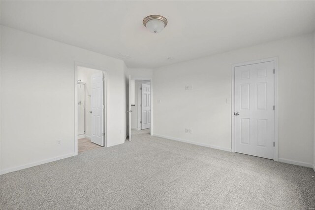 unfurnished bedroom with light carpet and ensuite bath