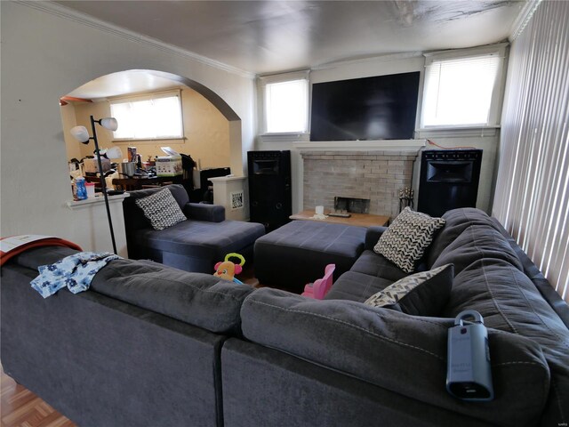 living room featuring a wealth of natural light, a fireplace, parquet flooring, and ornamental molding