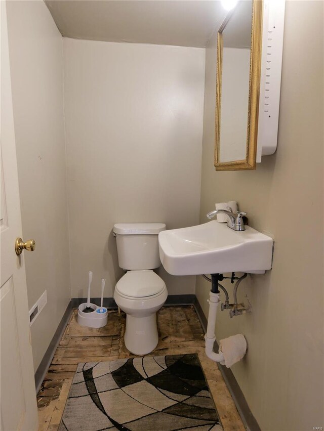 bathroom with toilet, hardwood / wood-style flooring, and sink