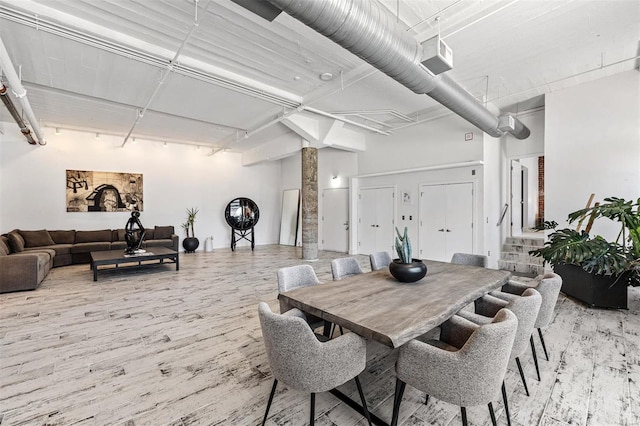 dining area with light wood-type flooring and rail lighting