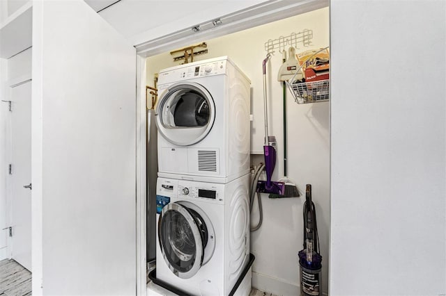 clothes washing area with stacked washer and clothes dryer