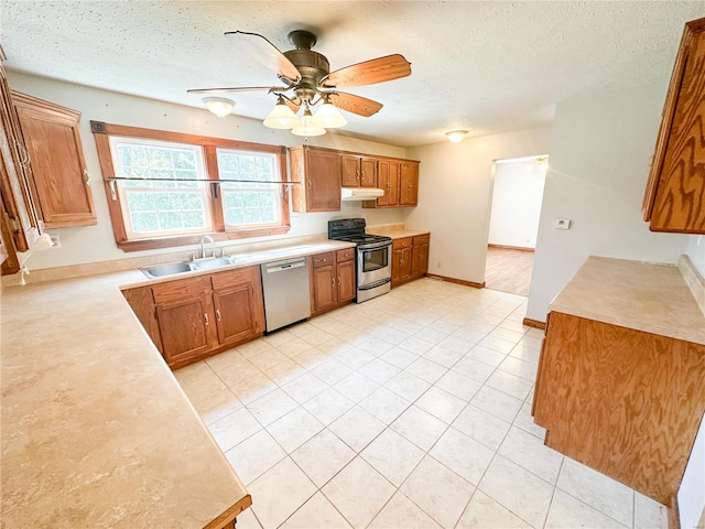 kitchen with appliances with stainless steel finishes, a textured ceiling, sink, and ceiling fan