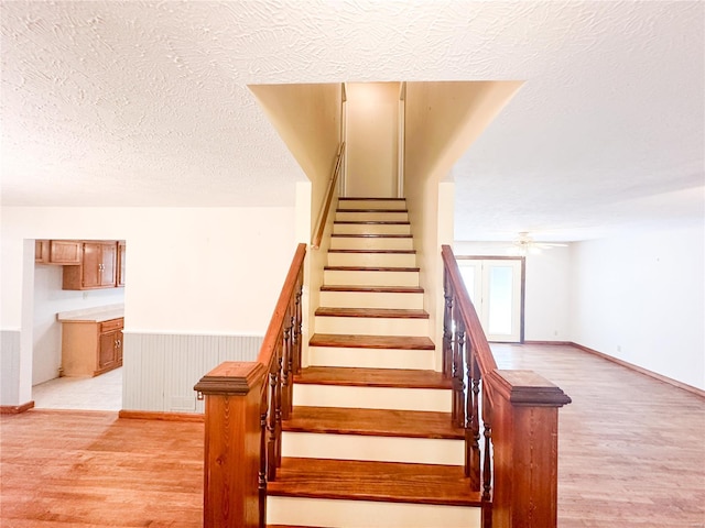 staircase featuring hardwood / wood-style floors and a textured ceiling